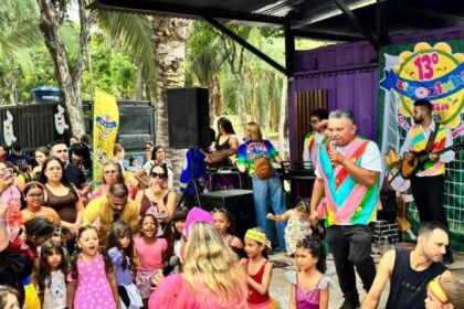 Crianças fantasiadas e famílias acompanham apresentação musical no Sivozinha Folia, em espaço aberto na Lagoa da Maraponga, em Fortaleza.