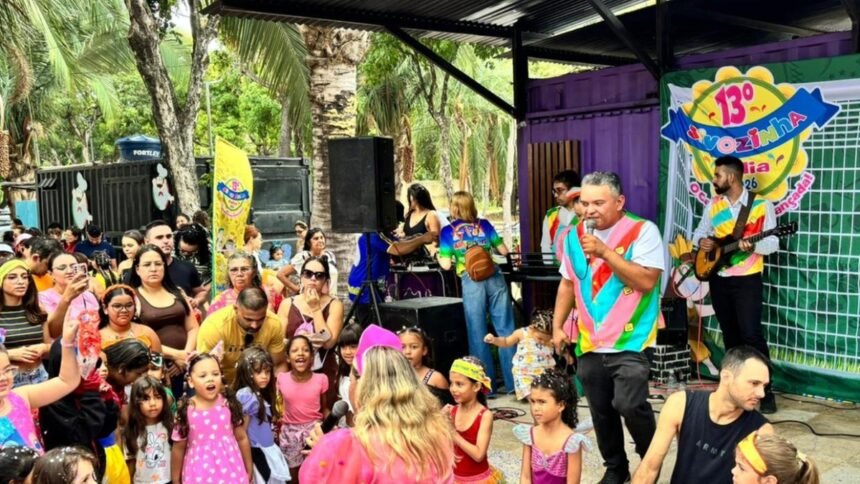 Crianças fantasiadas e famílias acompanham apresentação musical no Sivozinha Folia, em espaço aberto na Lagoa da Maraponga, em Fortaleza.