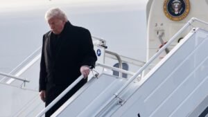 Donald Trump desce a escada do Air Force One no Aeroporto de Zurique, na Suíça, ao chegar para o Fórum Econômico Mundial, sob clima de tensão diplomática.