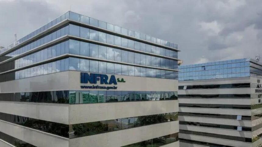 Prédio moderno da sede da Infra S.A., com fachada de vidro e logotipo da empresa, em área urbana de Brasília, sob céu nublado.