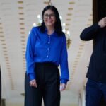 Delcy Rodríguez sorri entre Diosdado Cabello e Jorge Rodríguez no Palácio de Miraflores, em Caracas, antes de um pronunciamento oficial.