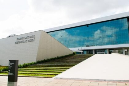 Fachada do Tribunal Regional Eleitoral do Ceará, em Fortaleza, prédio moderno com fachada de vidro e escadaria frontal.