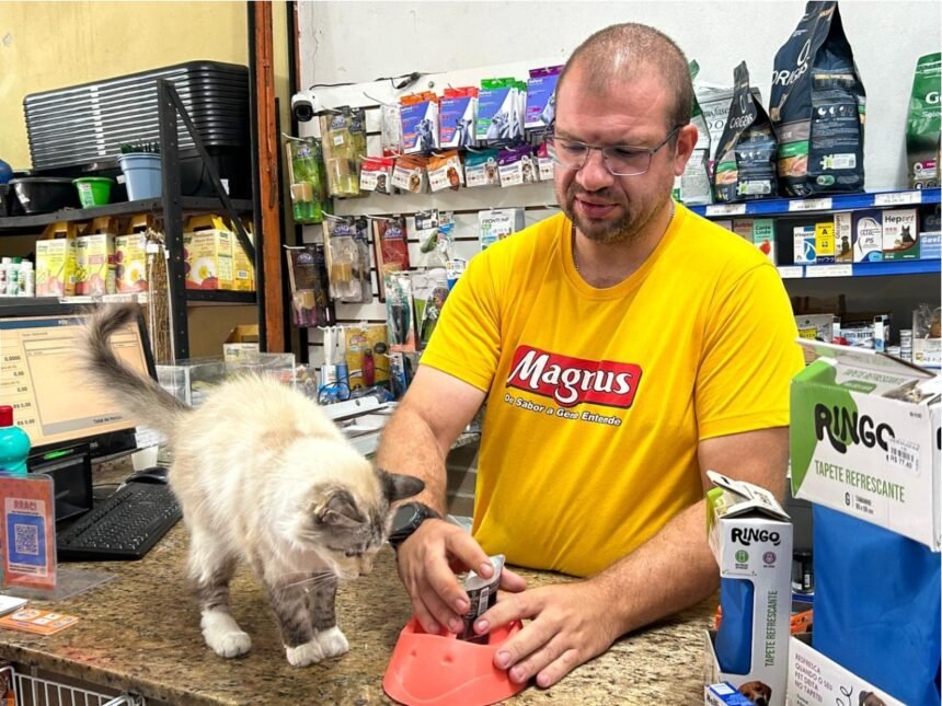 Décio Baccarini Neto, fundador da Raça & Ração, em pet shop durante atendimento, representando o crescimento dos pequenos negócios do mercado pet no Brasil.