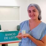 Mulher doadora de leite humano segura frasco de coleta no Banco de Leite do Hospital Universitário do Ceará.