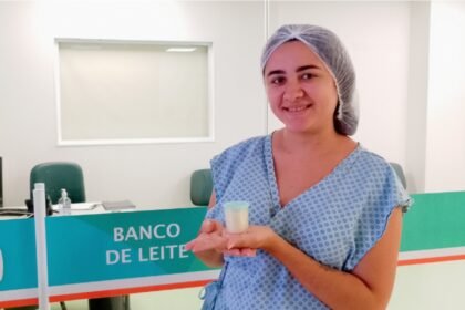 Mulher doadora de leite humano segura frasco de coleta no Banco de Leite do Hospital Universitário do Ceará.