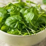 Folhas de agrião em recipiente utilizadas na alimentação saudável.