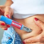 Pessoa aplicando caneta injetável para emagrecimento na região da barriga, medicamento da classe dos análogos de GLP-1. Canetas emagrecedoras.