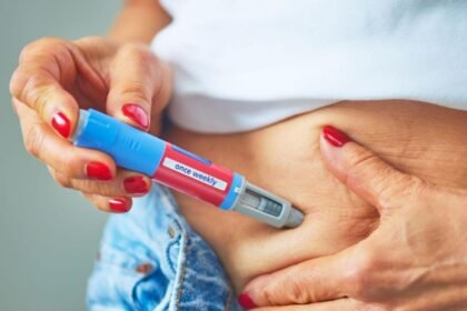 Pessoa aplicando caneta injetável para emagrecimento na região da barriga, medicamento da classe dos análogos de GLP-1. Canetas emagrecedoras.