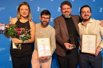Cineastas cearenses premiados na Berlinale 2026 seguram troféus e certificados após conquista de três prêmios em Berlim.