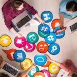 Empreendedores utilizam laptops e recursos digitais durante capacitação em marketing digital para pequenos negócios. Sebrae oferece curso gratuito.