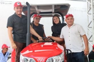 Autoridades e representantes da agricultura familiar posam sobre trator entregue pelo Governo do Ceará durante ação de fortalecimento da produção agrícola, no pátio da Secretaria do Desenvolvimento Agrário.