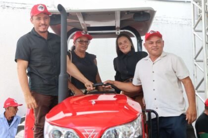 Autoridades e representantes da agricultura familiar posam sobre trator entregue pelo Governo do Ceará durante ação de fortalecimento da produção agrícola, no pátio da Secretaria do Desenvolvimento Agrário.