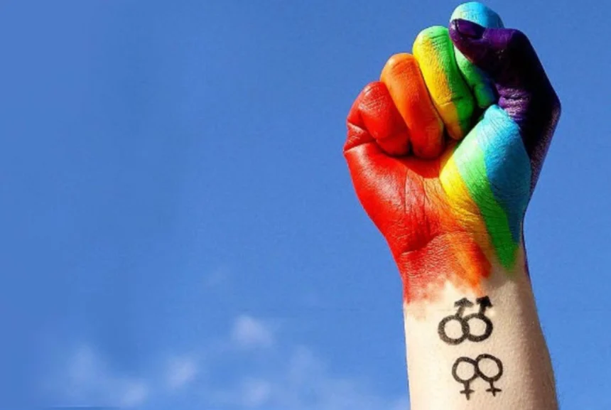 Punho com as cores do arco-íris simboliza a luta contra a violência e a proteção dos direitos da população LGBTI+.